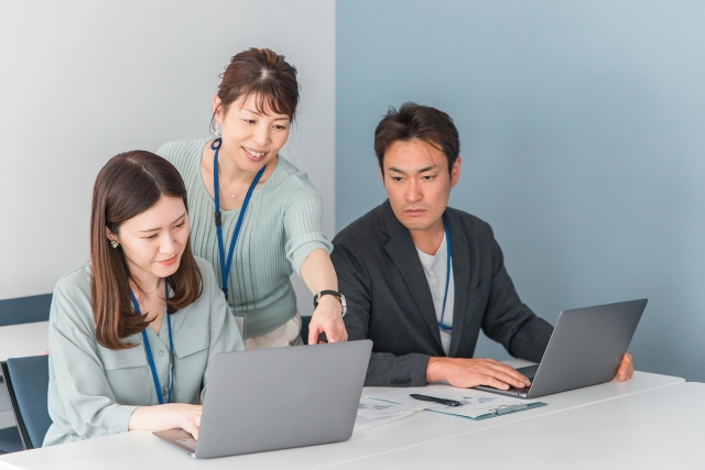 技術内容や発明について社内の担当者がパソコンを見ながら打ち合わせを行うイメージ